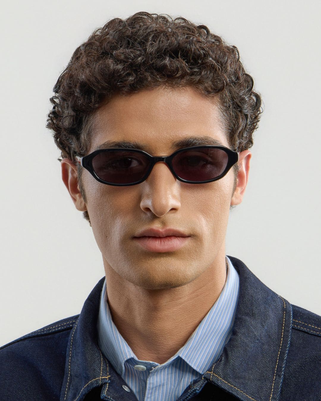 Man wearing black sunglasses with a plain background