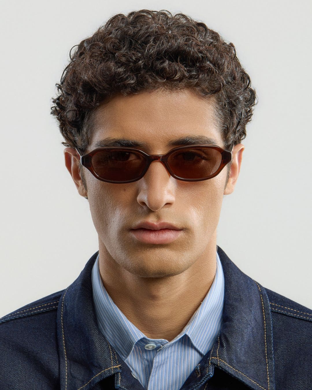 Male model wearing Corlin Eyewear Aidan Brown Brown sunglasses — front view, slim square acetate frame