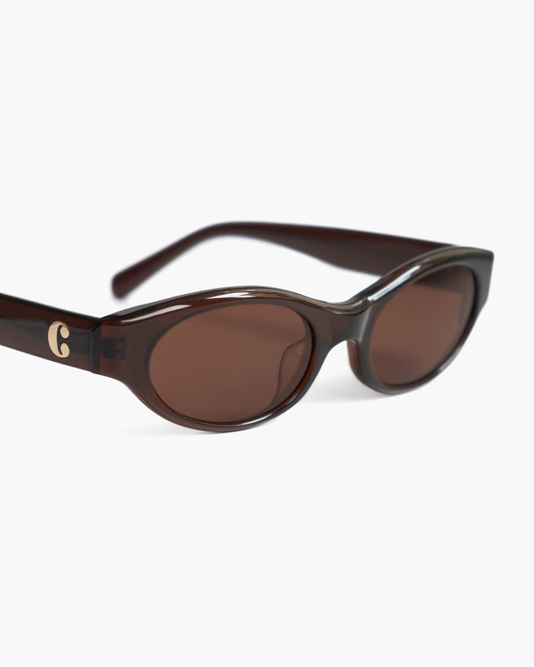Brown sunglasses with a logo on a white background slightly from the side