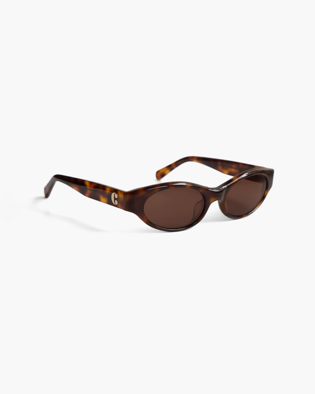 Sunglasses with tortoiseshell frame and brown lenses on a white background from the side