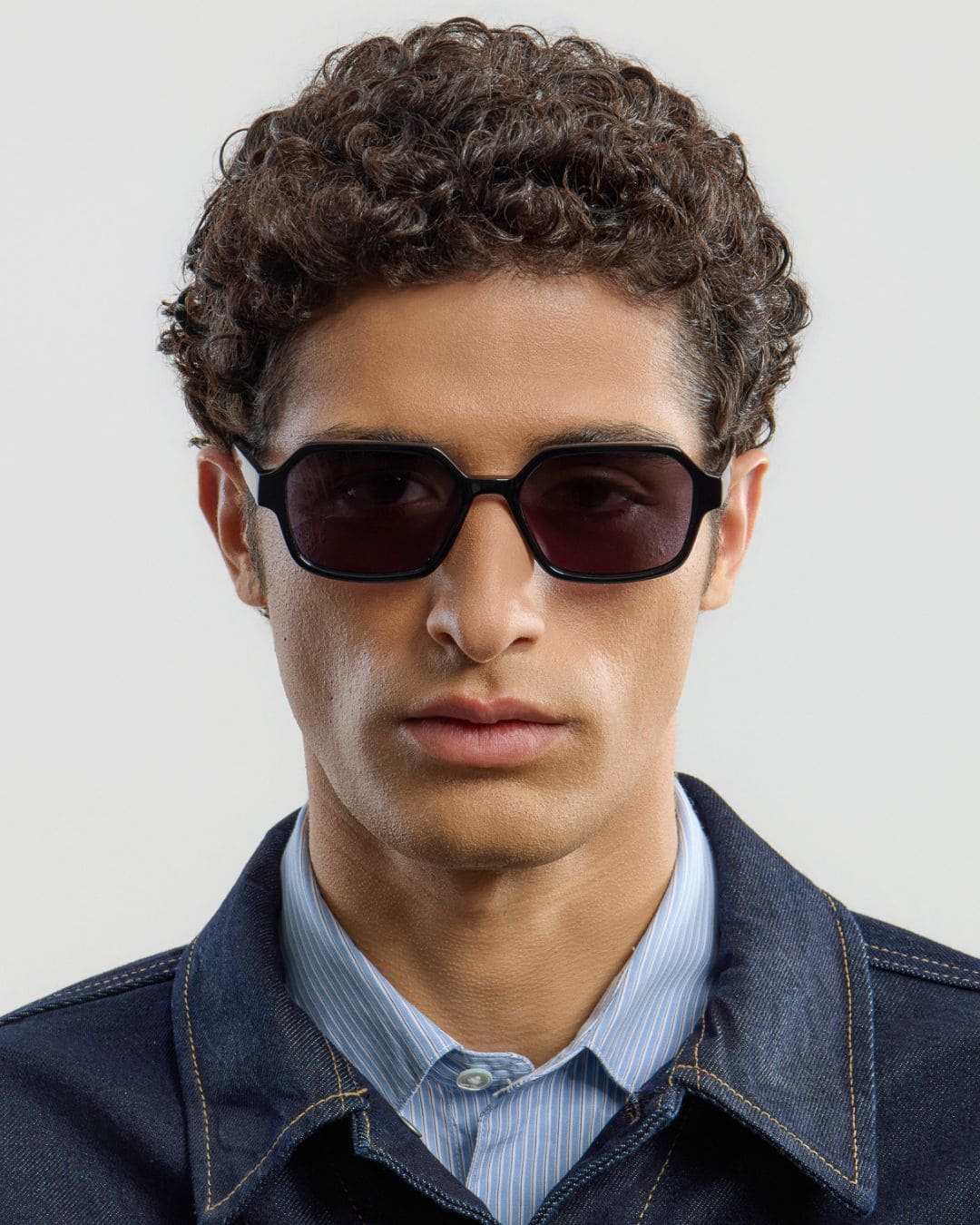 Man wearing black sunglasses with a plain background