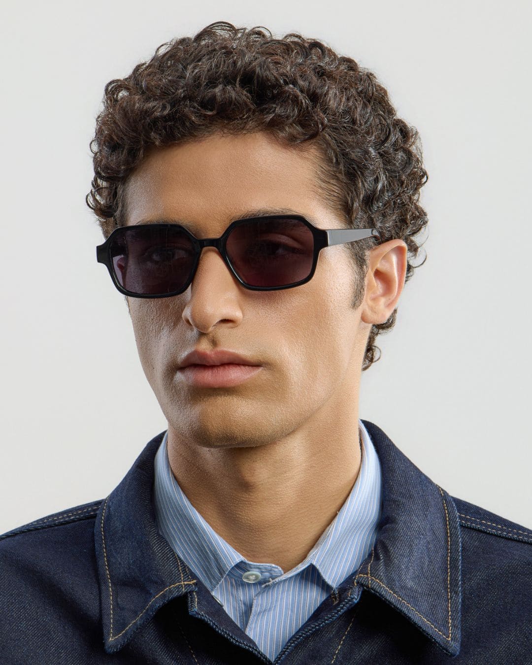 Man wearing black sunglasses with a neutral background
