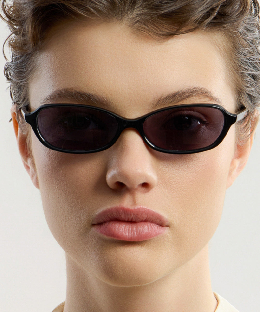 Female model wearing Corlin Eyewear Ana Black Black sunglasses — close-up, timeless cat-eye eyewear