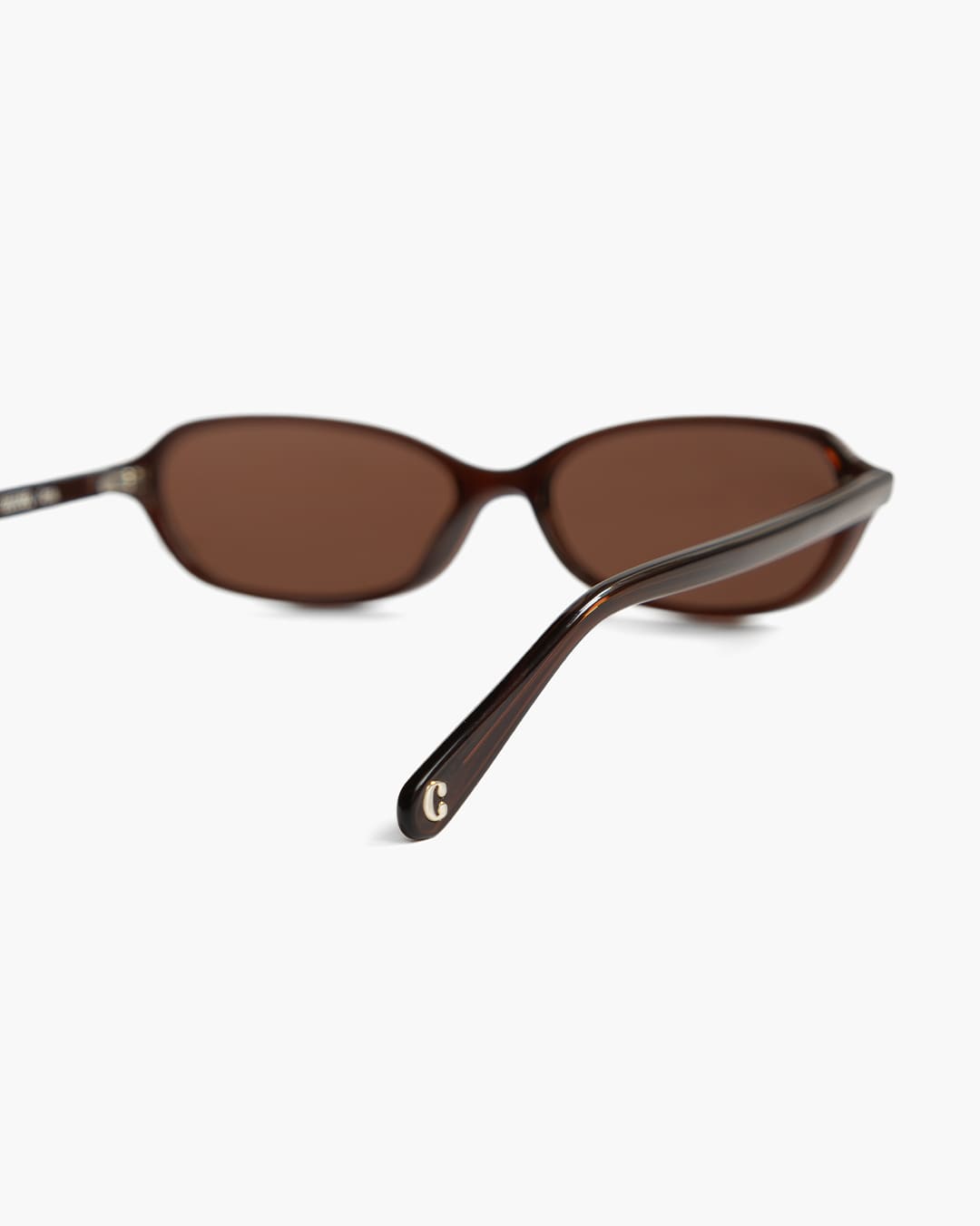 Brown sunglasses with a visible logo from the back on a white background