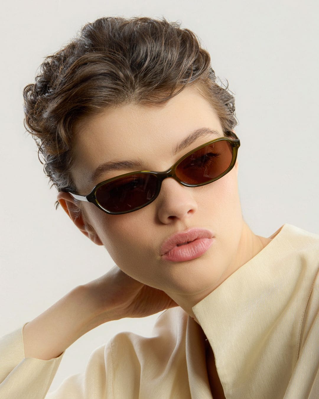 Woman wearing Ana Olive Brown sunglasses by Corlin - model pose.