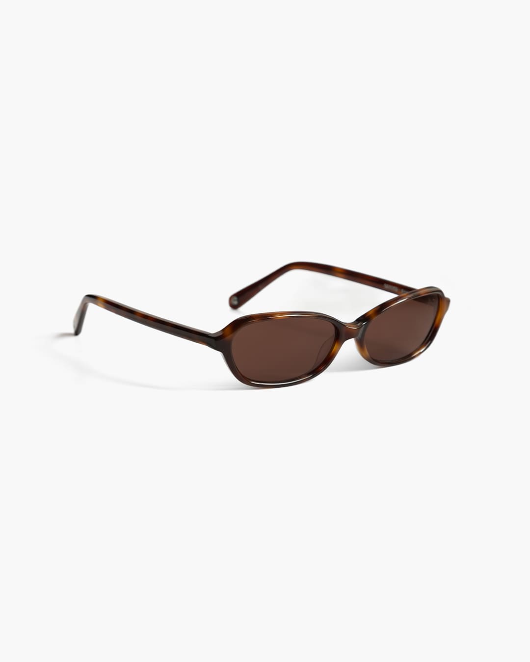 Sunglasses with tortoiseshell frame and brown lenses on a white background slightly from the side