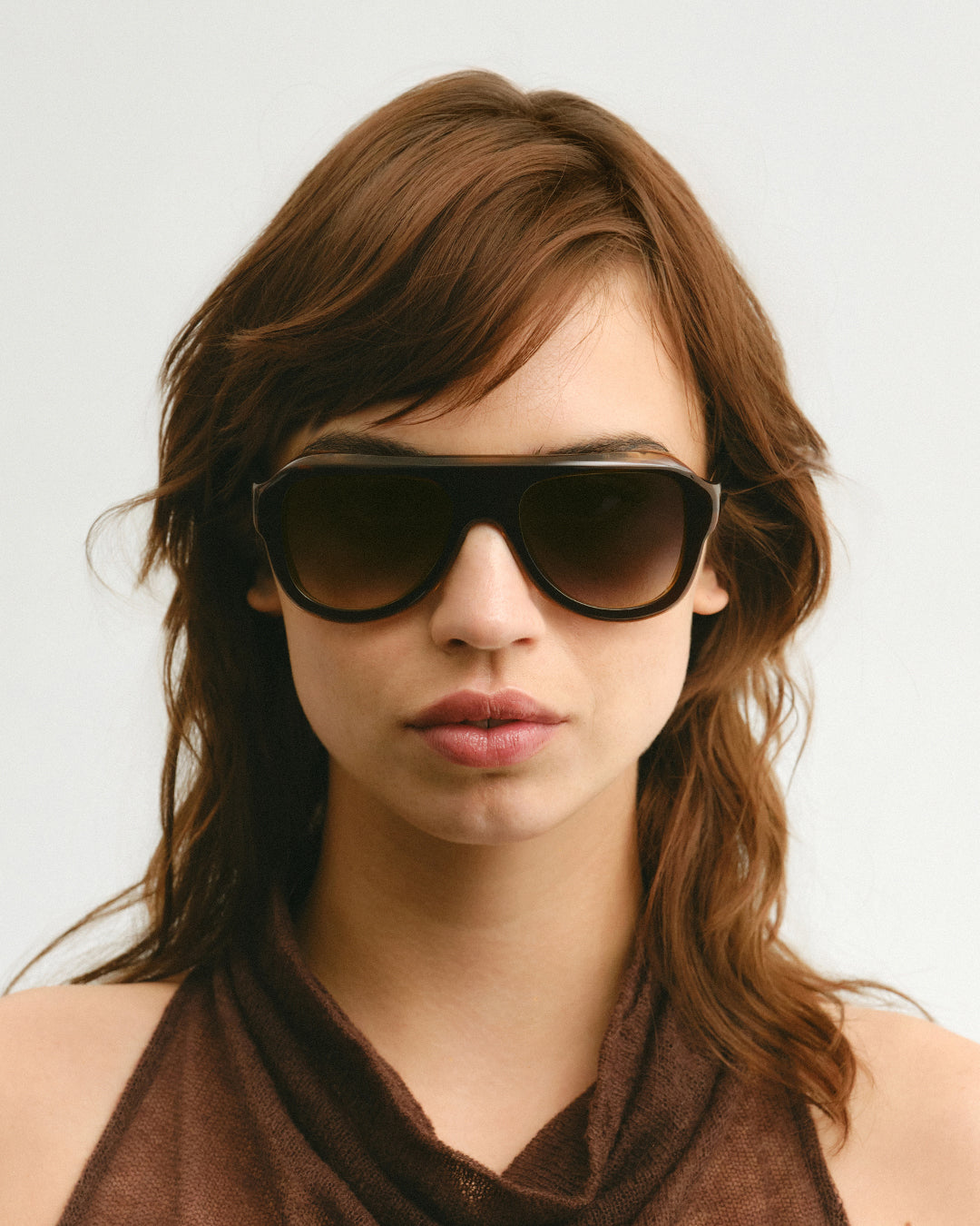 Female model wearing Corlin Eyewear Bernard Brown Gradual Brown sunglasses — front view, thick bio-acetate aviator frame