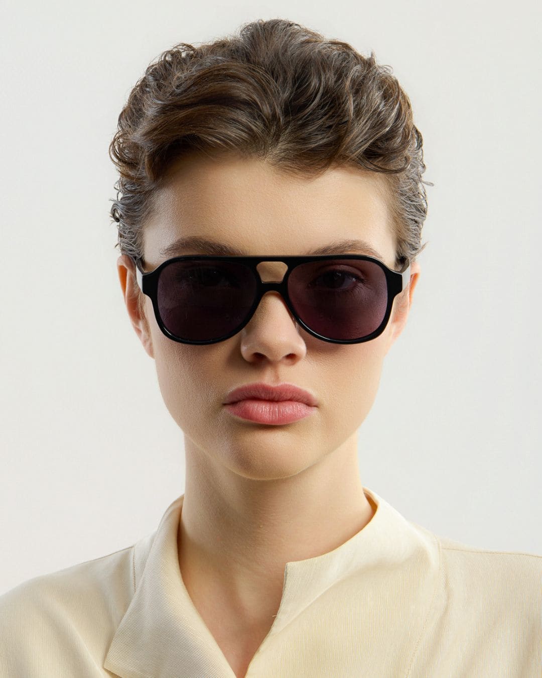 Woman wearing black sunglasses with a plain background