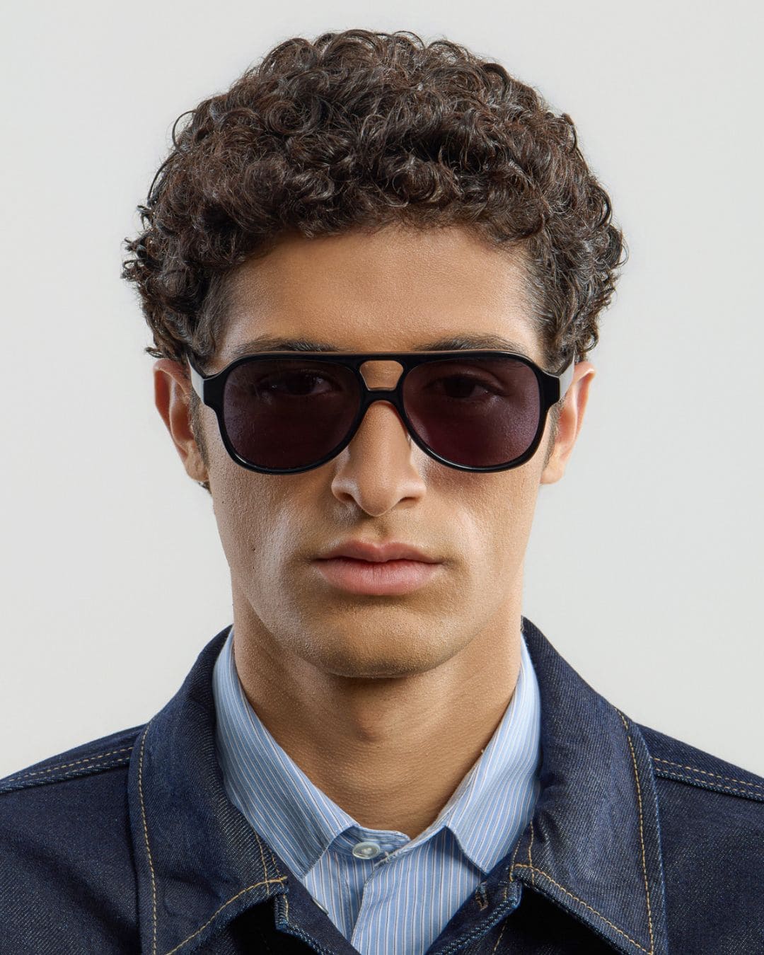 Man wearing black sunglasses with a plain background