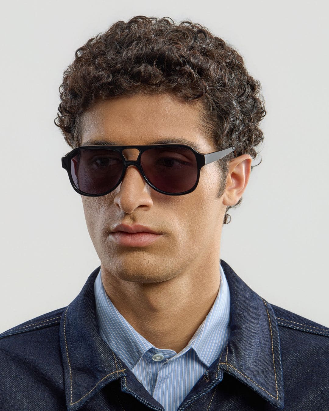 Man wearing black sunglasses with a plain background