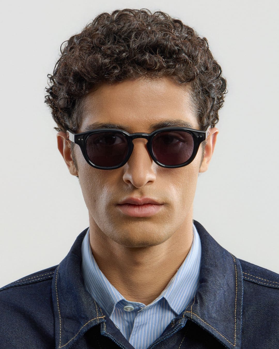 Man wearing black sunglasses with a plain background