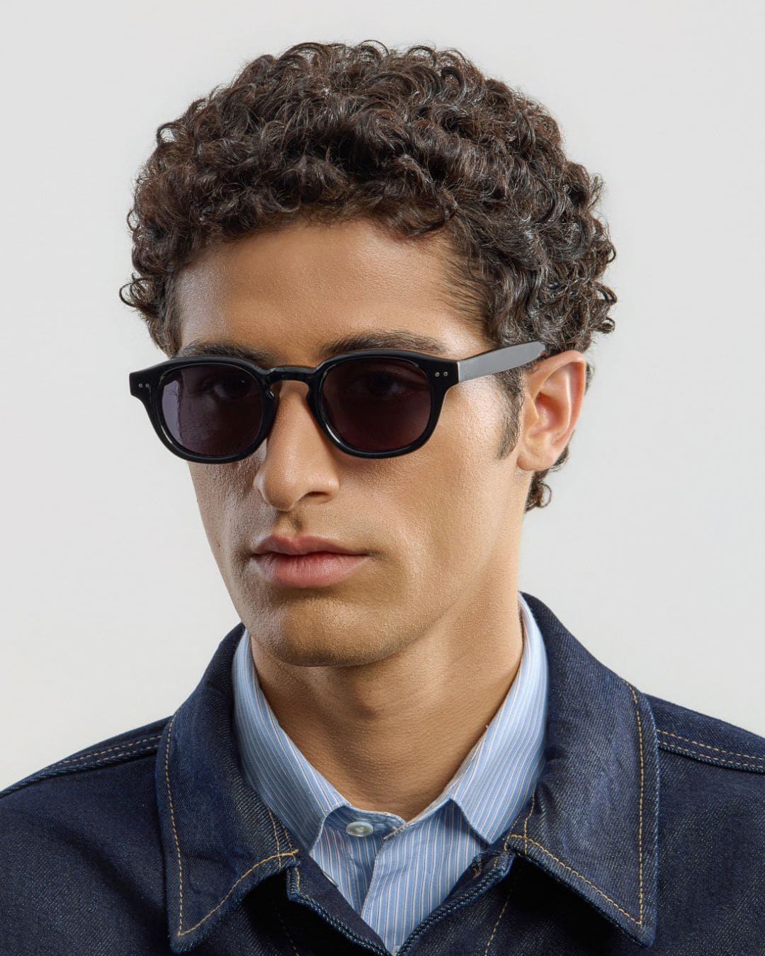 Man wearing black sunglasses with a neutral background
