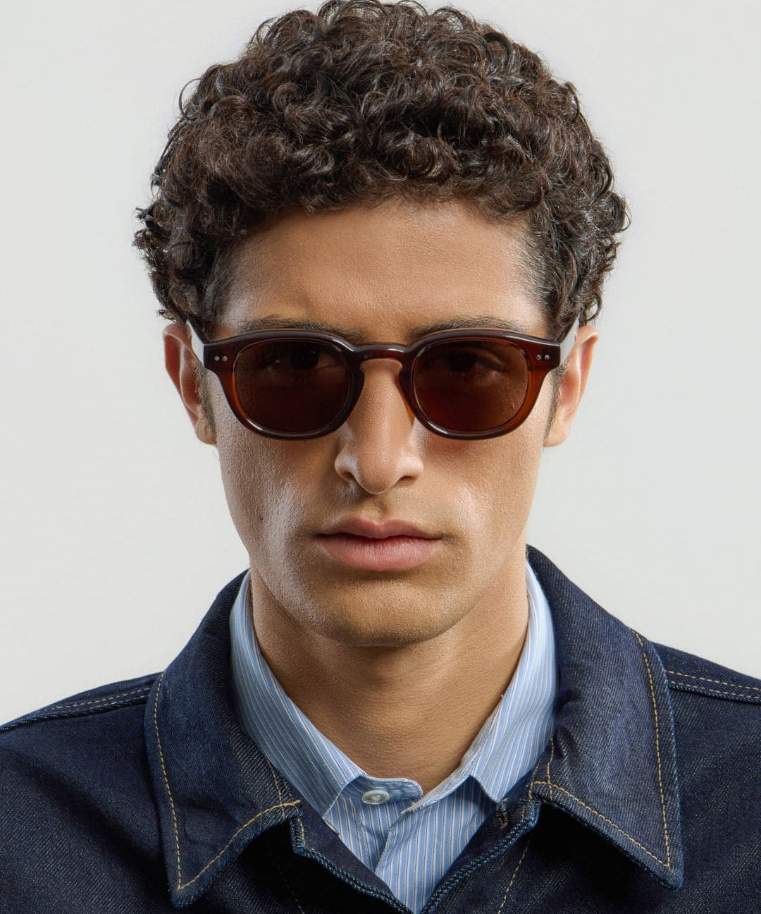 Male model wearing Corlin Eyewear Idris Brown Brown sunglasses — close-up, timeless round unisex eyewear