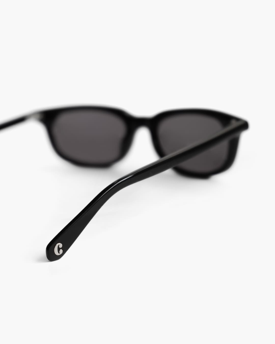 Black sunglasses from the back with a blurred background ad focus on the logo