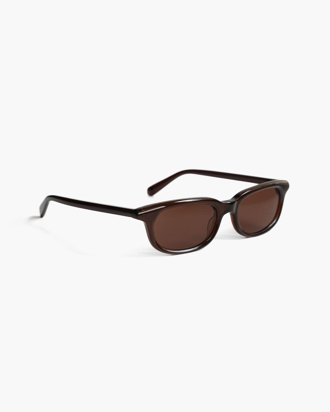 Sunglasses with brown lenses on a white background slightly from the side