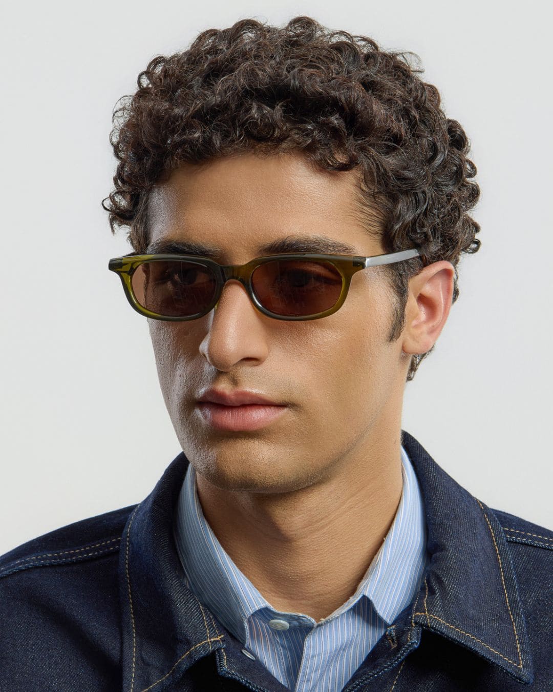 Male model wearing Corlin Eyewear Jean Olive Brown sunglasses — side profile, slim unisex acetate frame