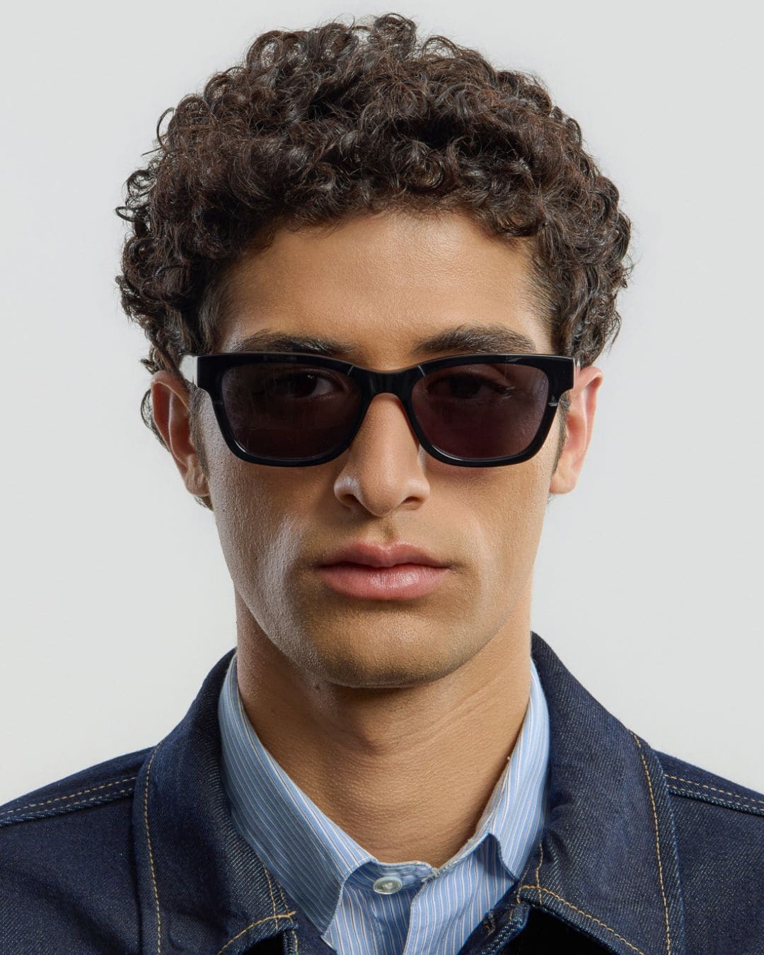 Man wearing black sunglasses with a neutral background