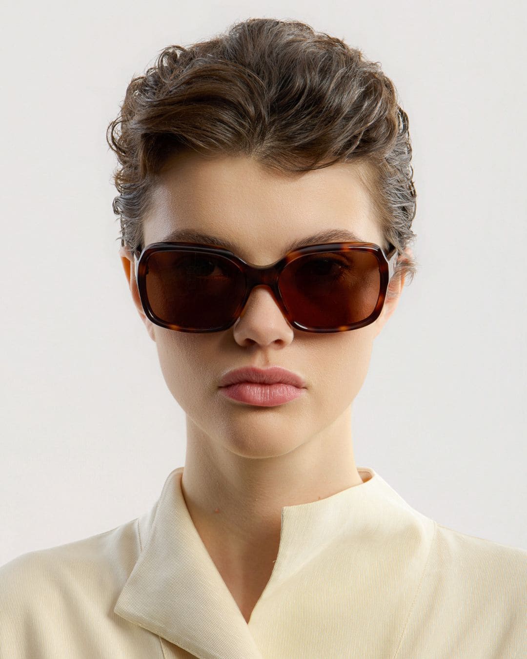 Female model wearing Corlin Eyewear Lana Tortoise Brown sunglasses — front view, bold squared Italian acetate frame