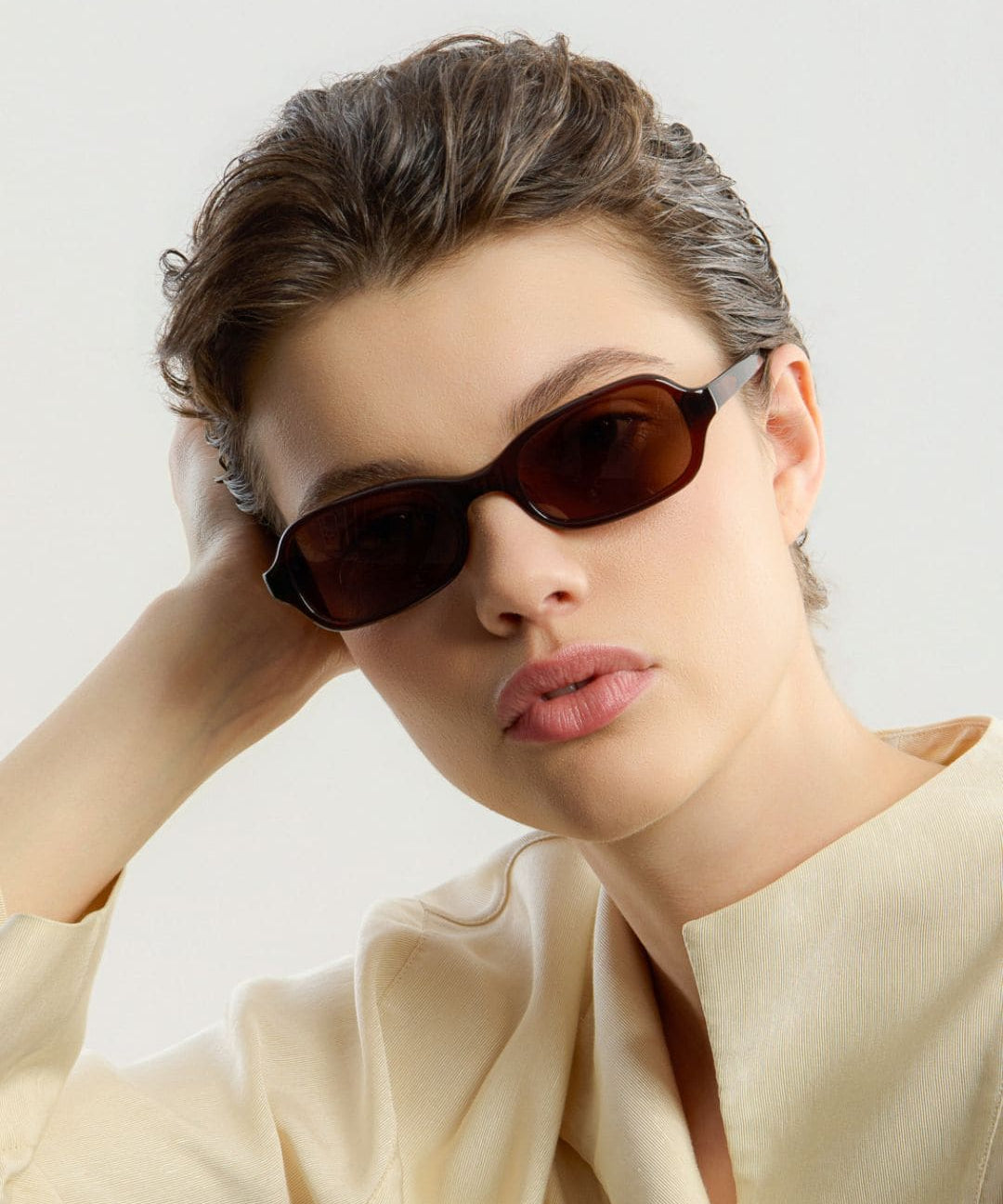 Female model wearing Corlin Eyewear Lou Brown Brown sunglasses — timeless squared eyewear, Scandinavian design