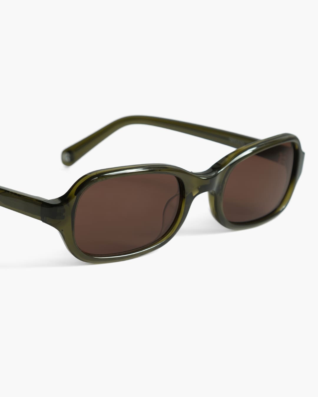 Closeup of sunglasses with green frame and brown lenses on a white background