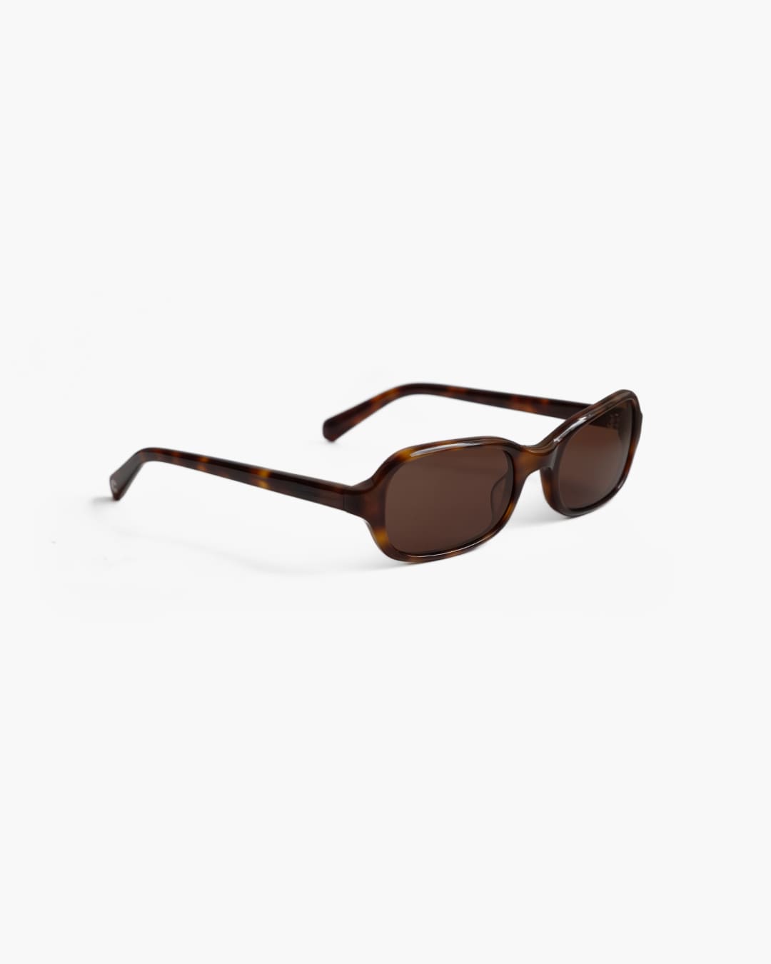 Brown sunglasses with tortoiseshell frame on a white background slightly from the side