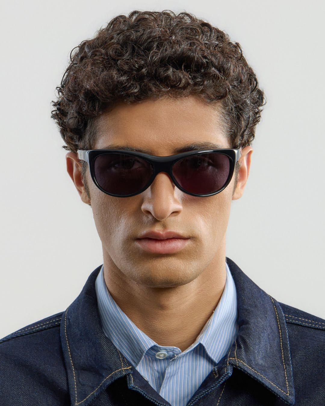 Male model wearing Corlin Eyewear Lynne Black sunglasses — front view, sculpted wraparound fit