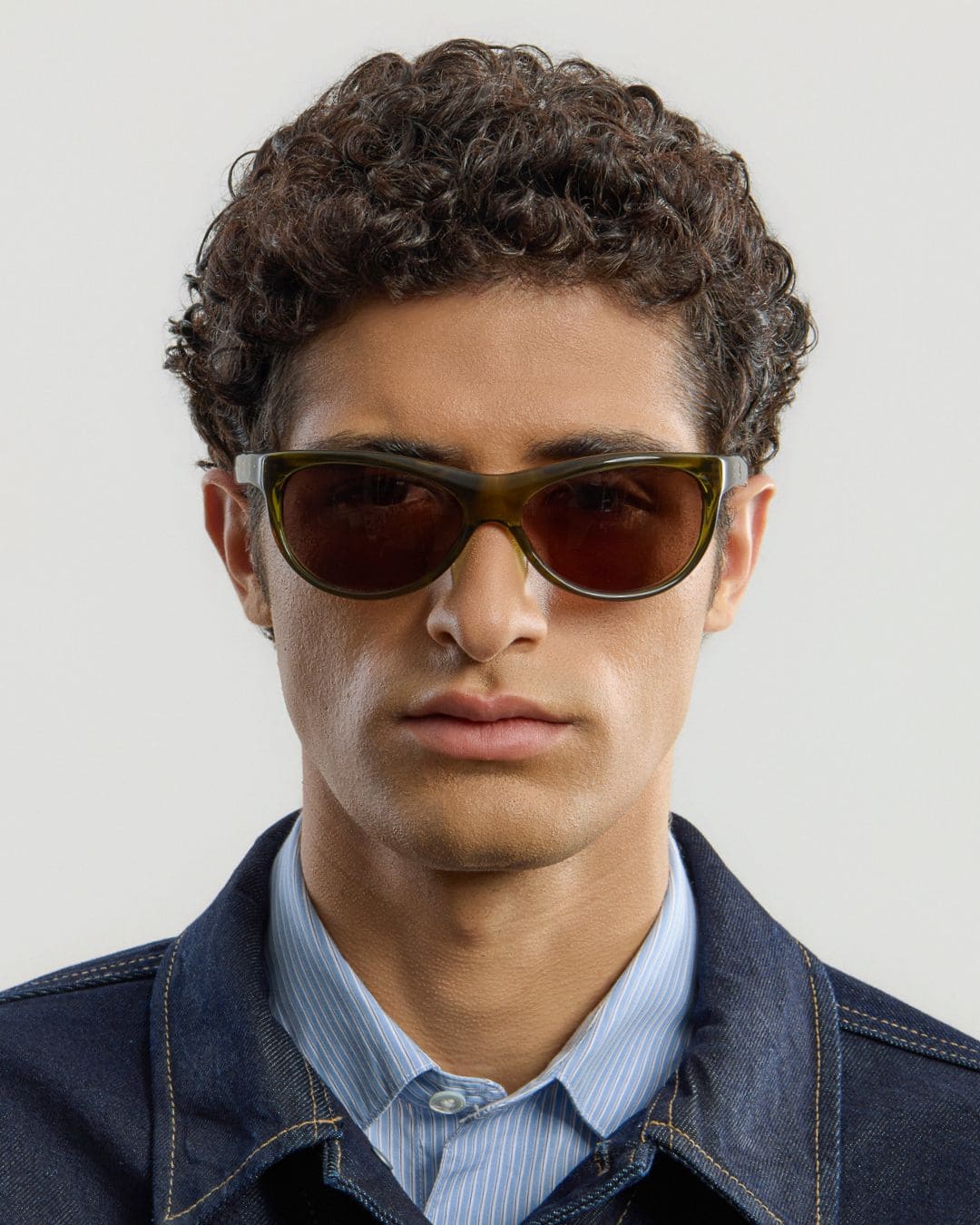 Male model wearing Corlin Eyewear Lynne Olive Brown sunglasses — front view, sculpted wraparound fit