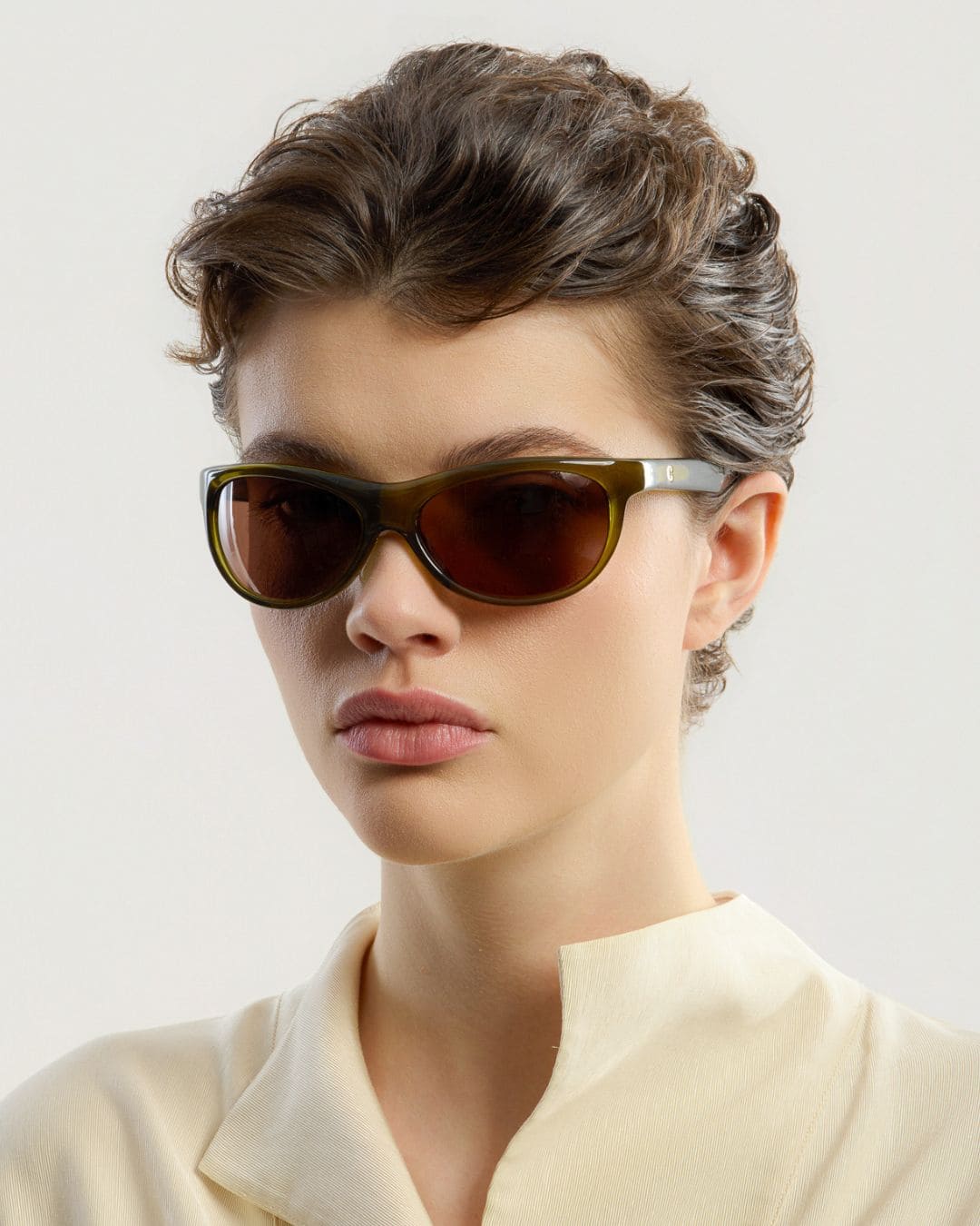 Female model wearing Corlin Eyewear Lynne Olive Brown sunglasses — side profile, Swedish minimalist wraparound design
