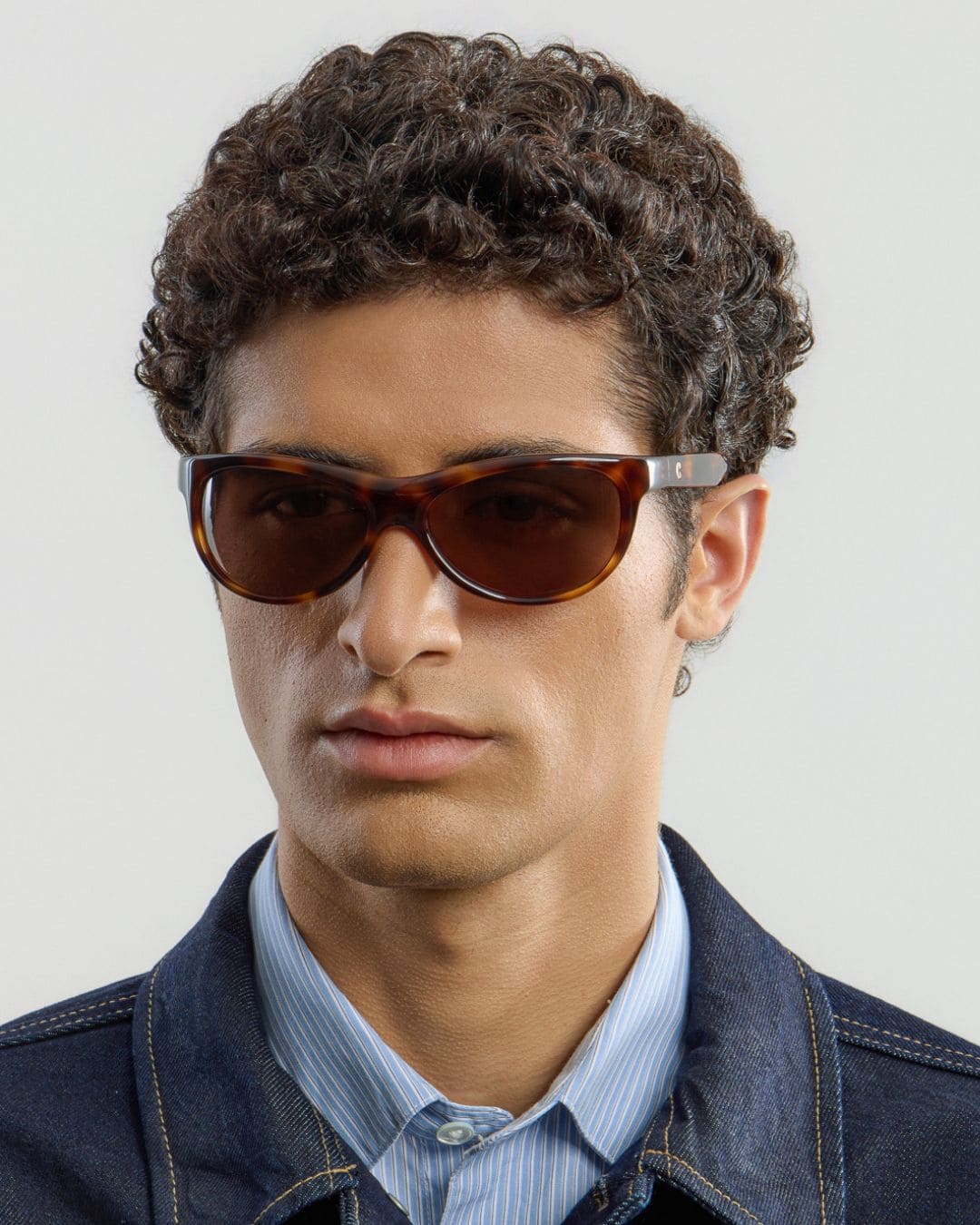 Male model wearing Corlin Eyewear Lynne Tortoise Brown sunglasses — side profile, wraparound fit on face