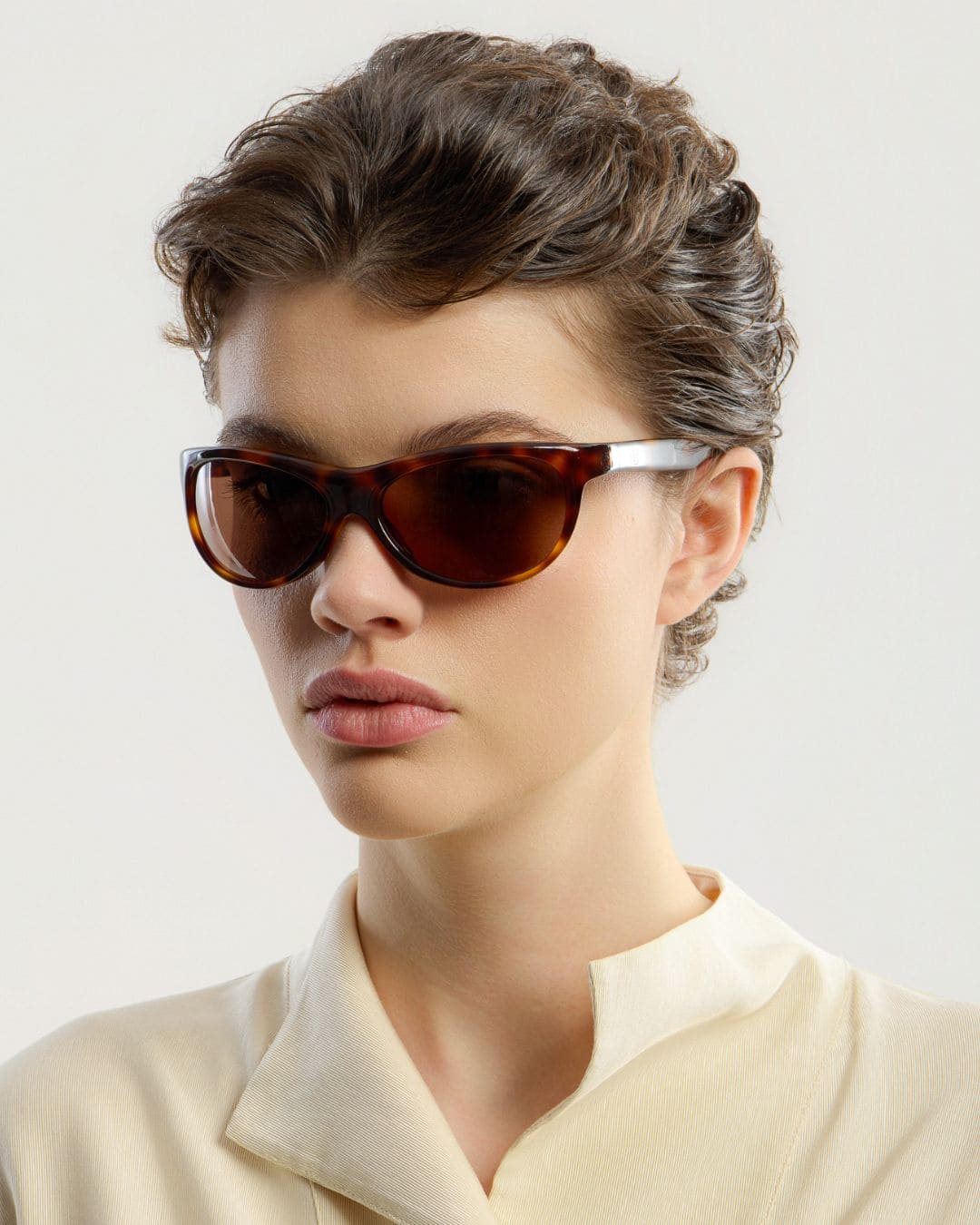 Female model wearing Corlin Eyewear Lynne Tortoise Brown sunglasses — side profile, Swedish minimalist wraparound design