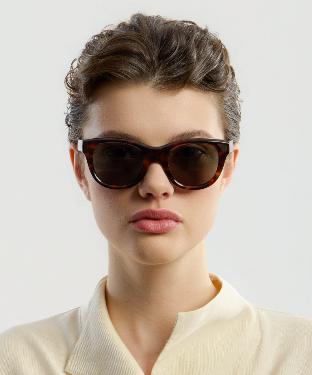 Female model wearing Corlin Eyewear Rey Tortoise Green sunglasses — front view, oversized cat-eye silhouette