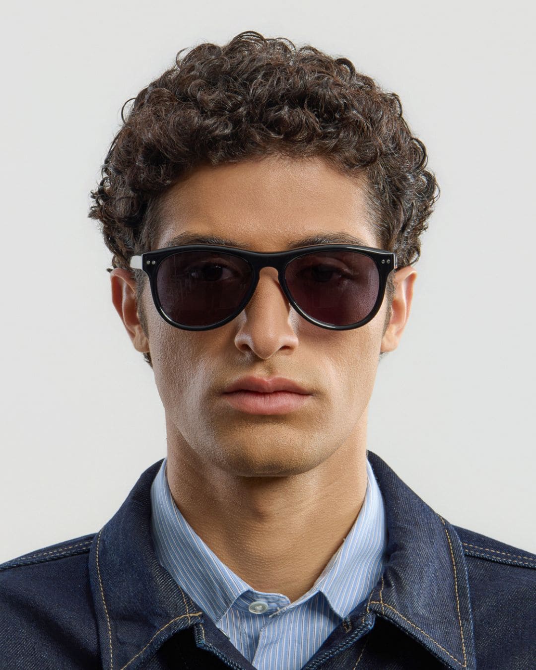 Male model wearing Corlin Eyewear Sonney Black Black sunglasses — front view, sculpted Italian acetate frame