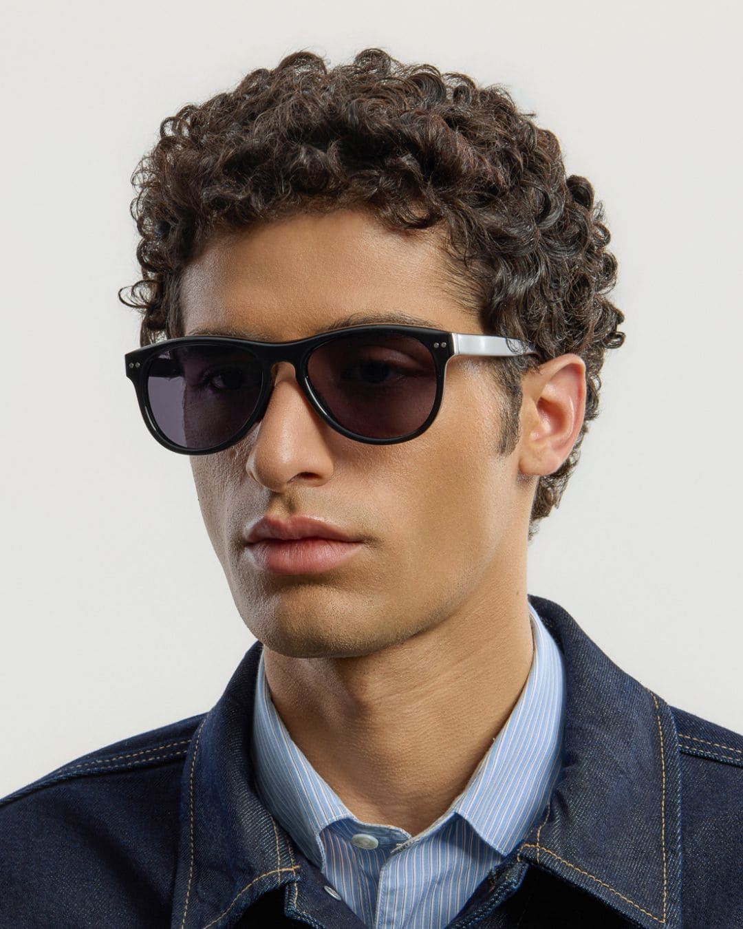 Male model wearing Corlin Eyewear Sonney Black Black sunglasses — side profile, timeless acetate design