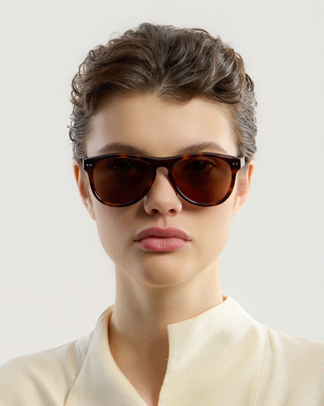 Female model wearing Corlin Eyewear Sonney Tortoise Brown sunglasses — front view, Italian acetate frame