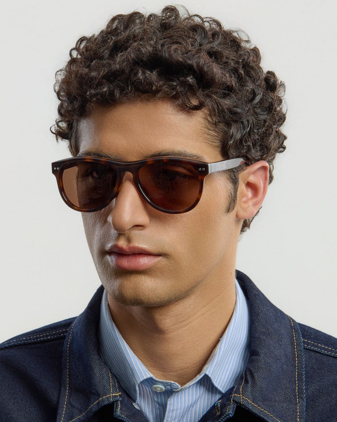 Male model wearing Corlin Eyewear Sonney Tortoise Brown sunglasses — side profile, timeless acetate design