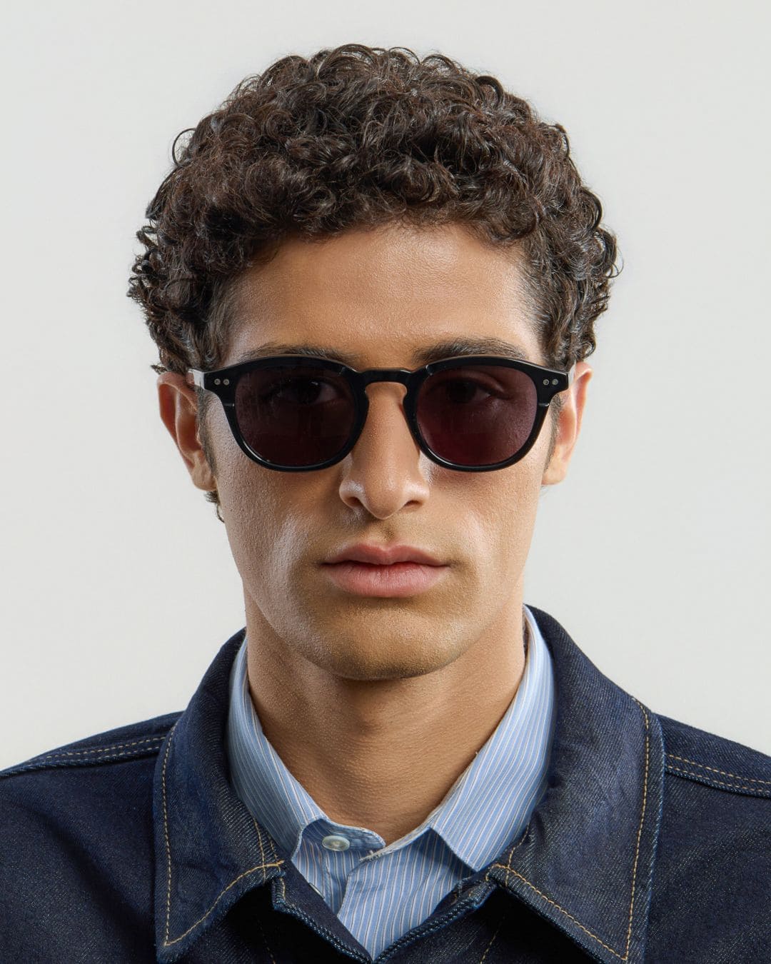 Man wearing black sunglasses with a plain background