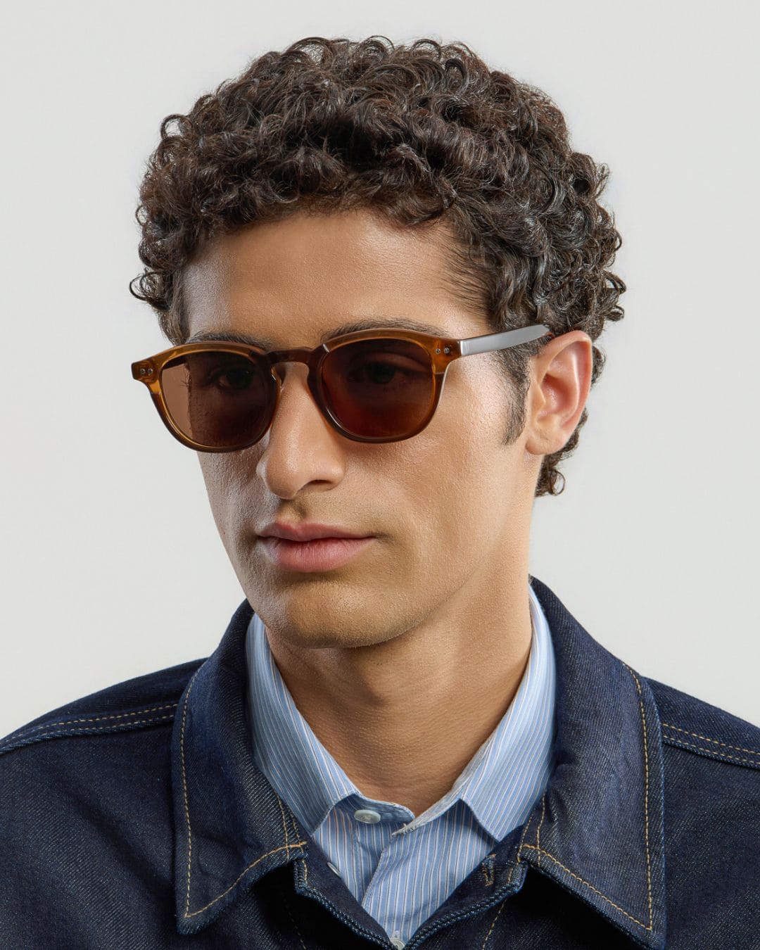 Man wearing brown brown sunglasses with a neutral background