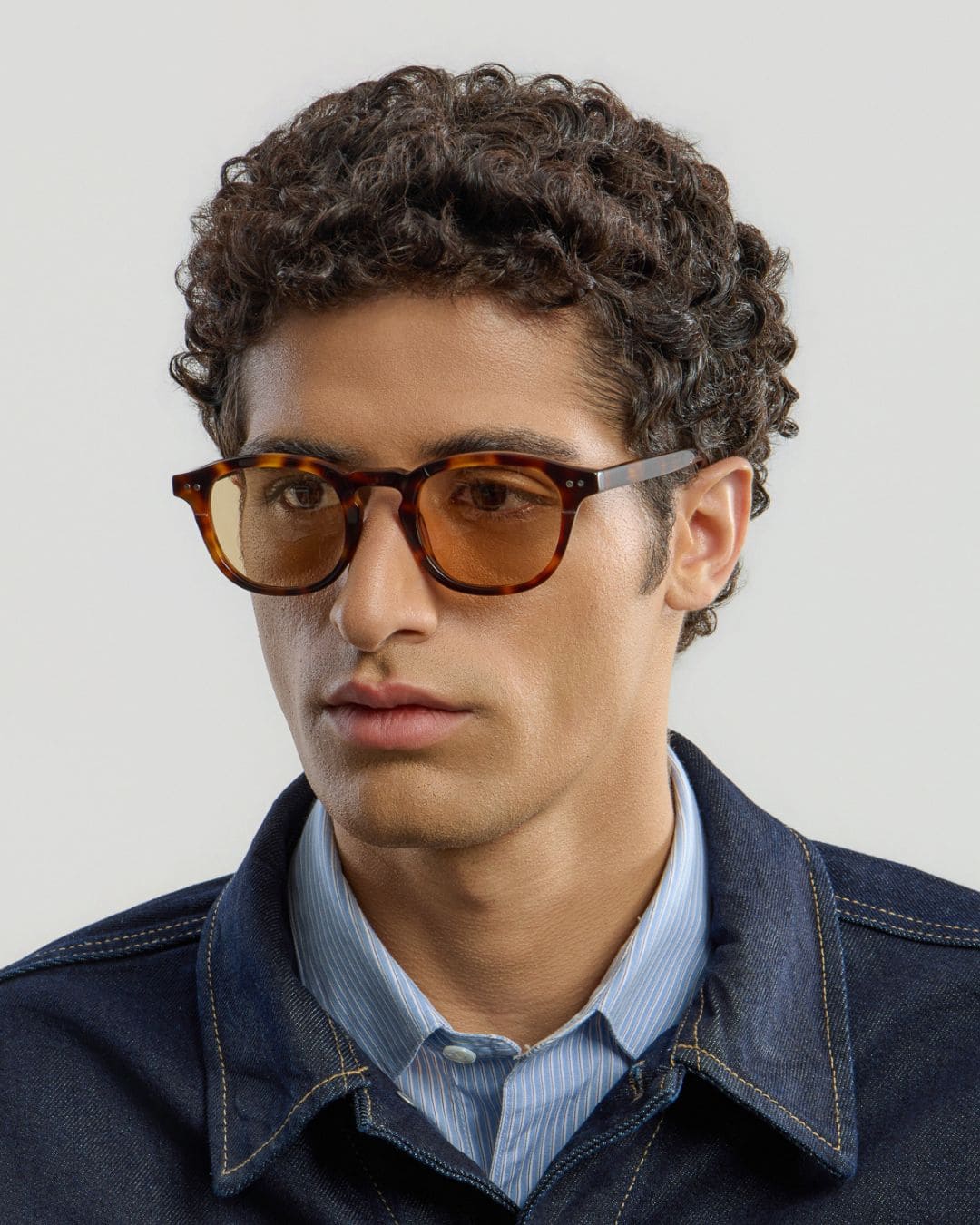 Man wearing brown cinnamon sunglasses with a neutral background