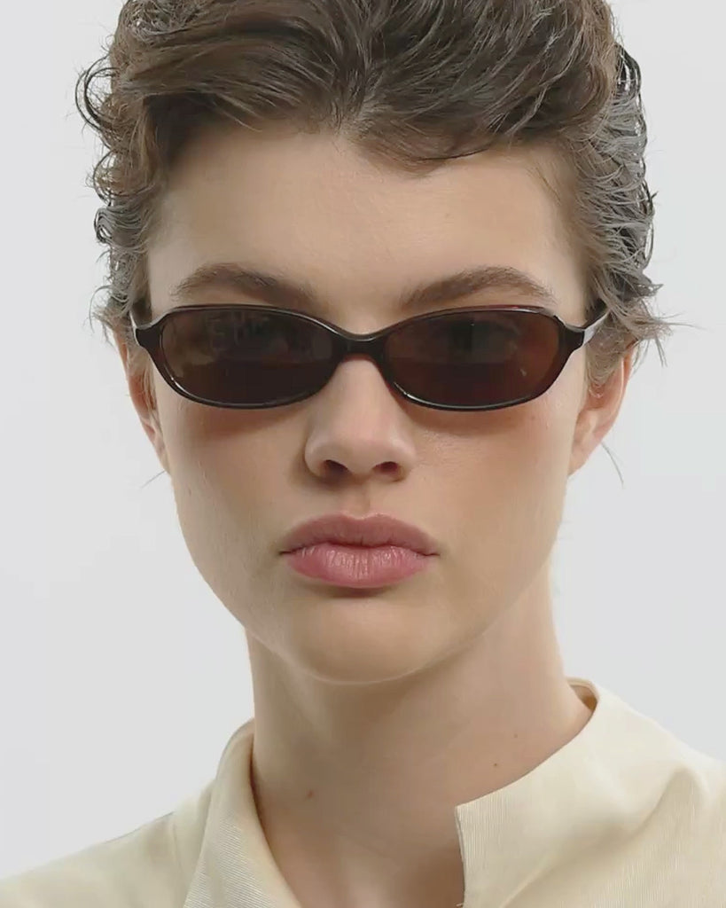 Video of woman wearing brown sunglasses looking straight and to the side